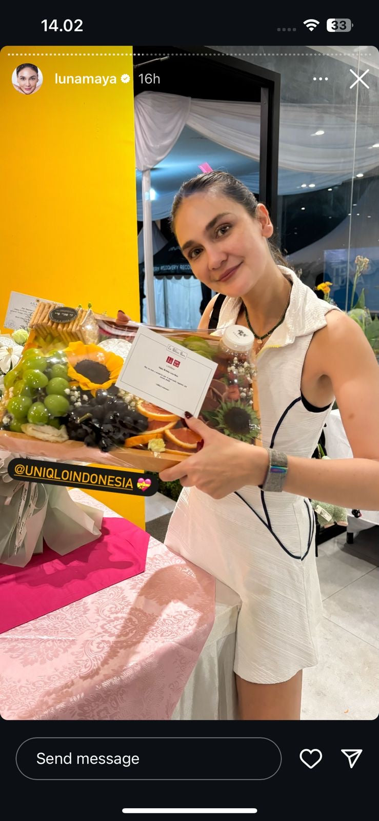 Luna Maya holding a box of charcuterie board aka cheese platter in a paddle field