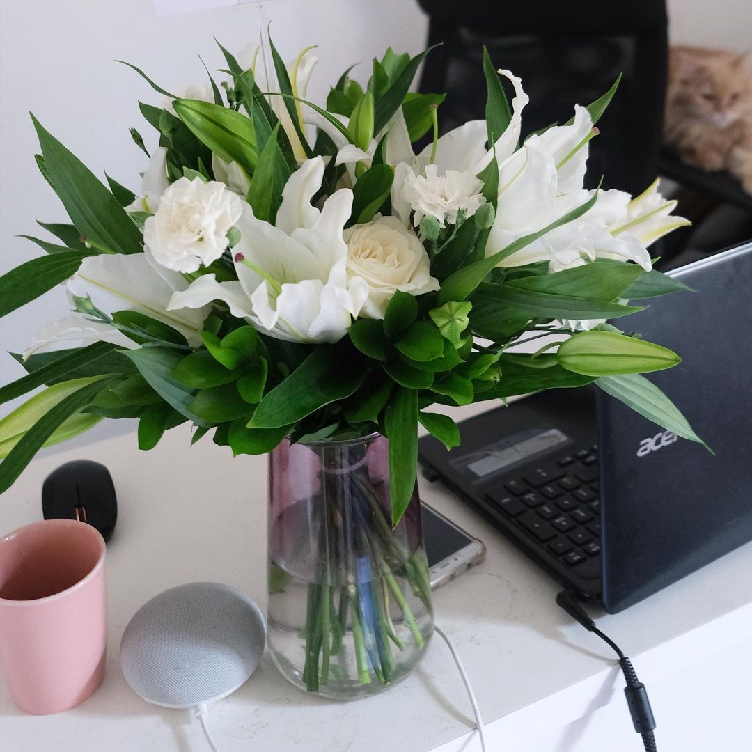 A fresh vase arrangement of white lilies and other white flowers on a table by Le Bliss Bouquet. Best florist in jakarta, tangerang, surabaya, cirebon