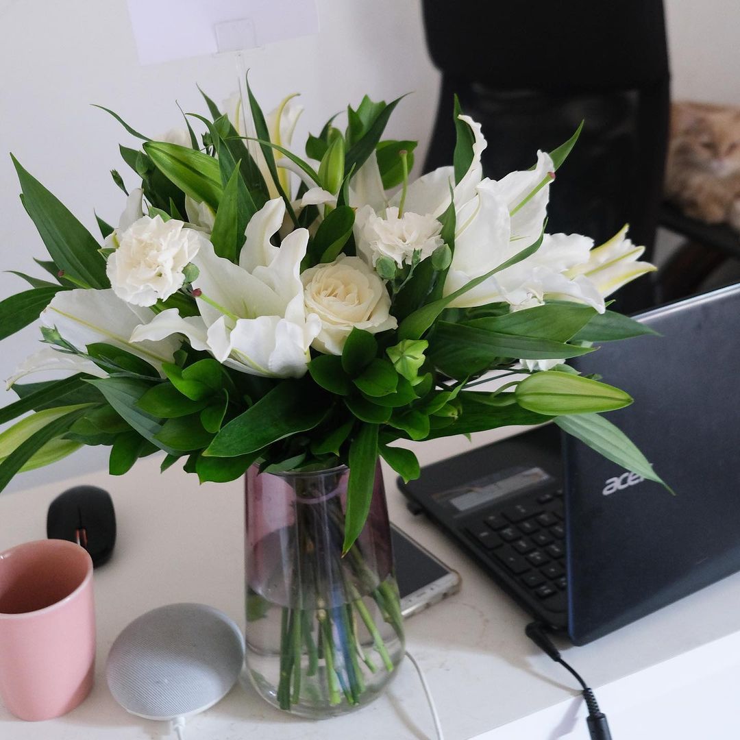 A fresh vase arrangement of white lilies and other white flowers on a table by Le Bliss Bouquet. Best florist in jakarta, tangerang, surabaya, cirebon, jabodetabek
