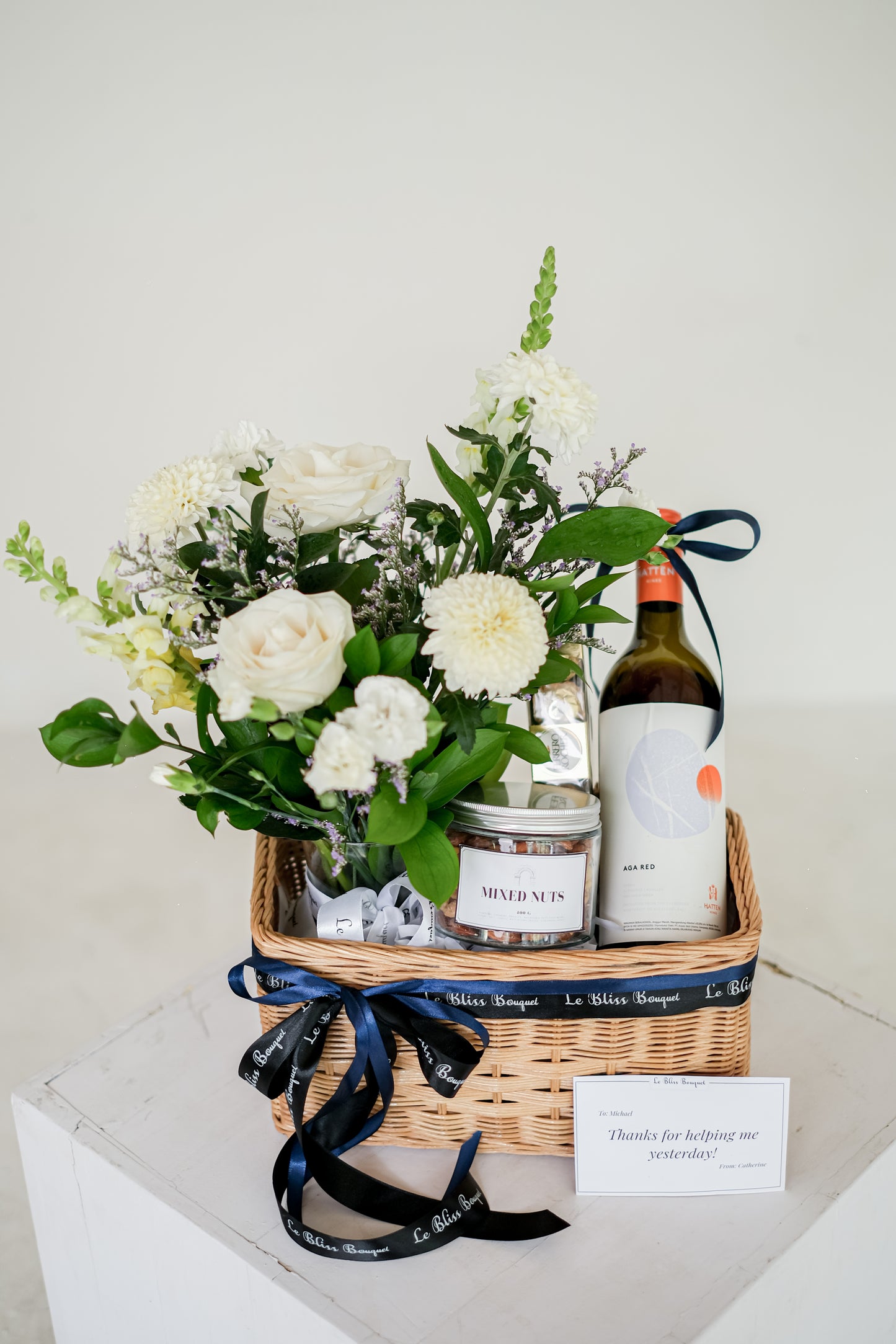 wine hamper surabaya, wine hamper jakarta by le bliss. hate wine, mixed nuts, Ferrero, and fresh flowers in vase rattan