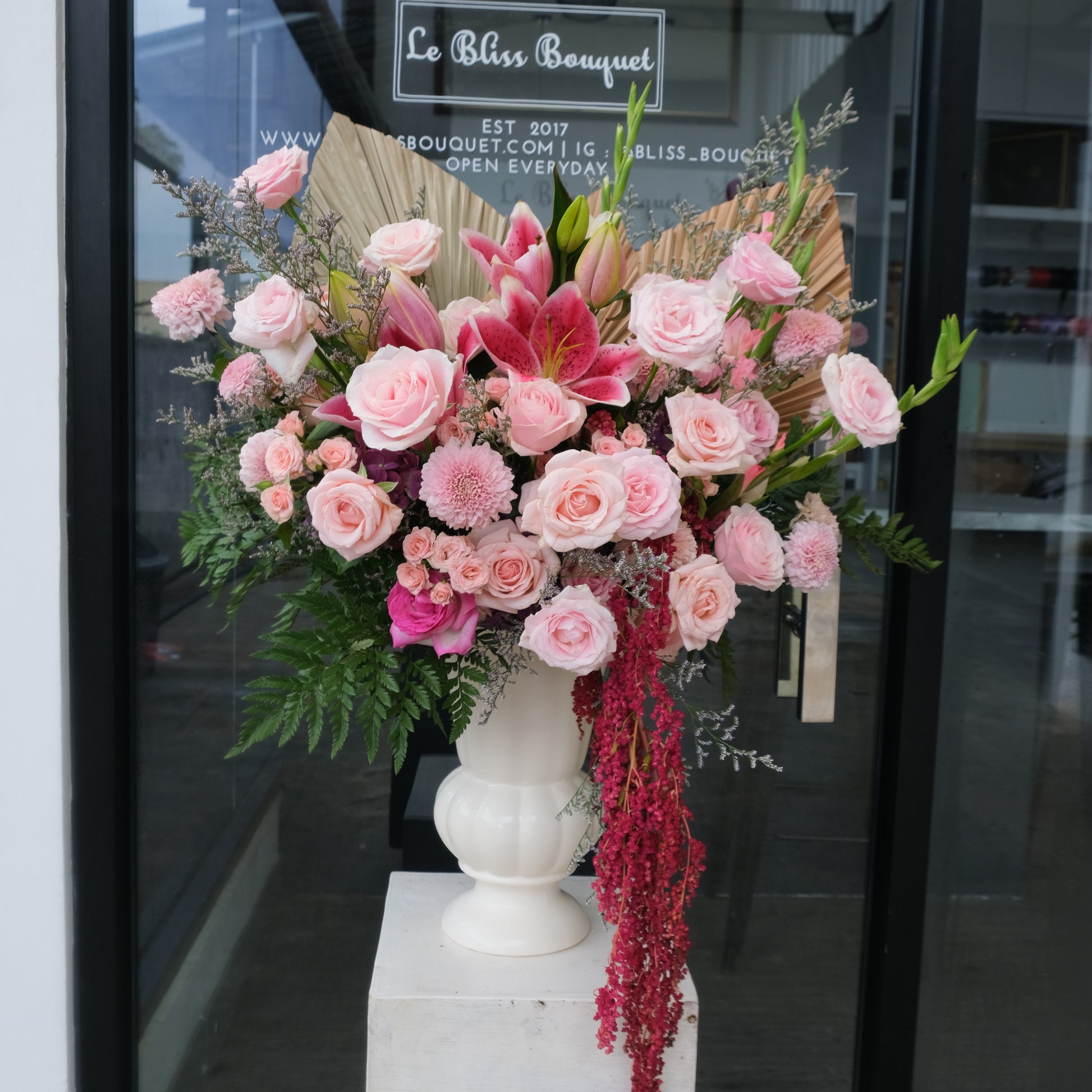 A vase arrangement featuring a variety of pink flowers, including roses and lilies, with greenery by Le Bliss Bouquet. Florist surabaya, toko bunga surabaya, rangkaian bunga surabaya
