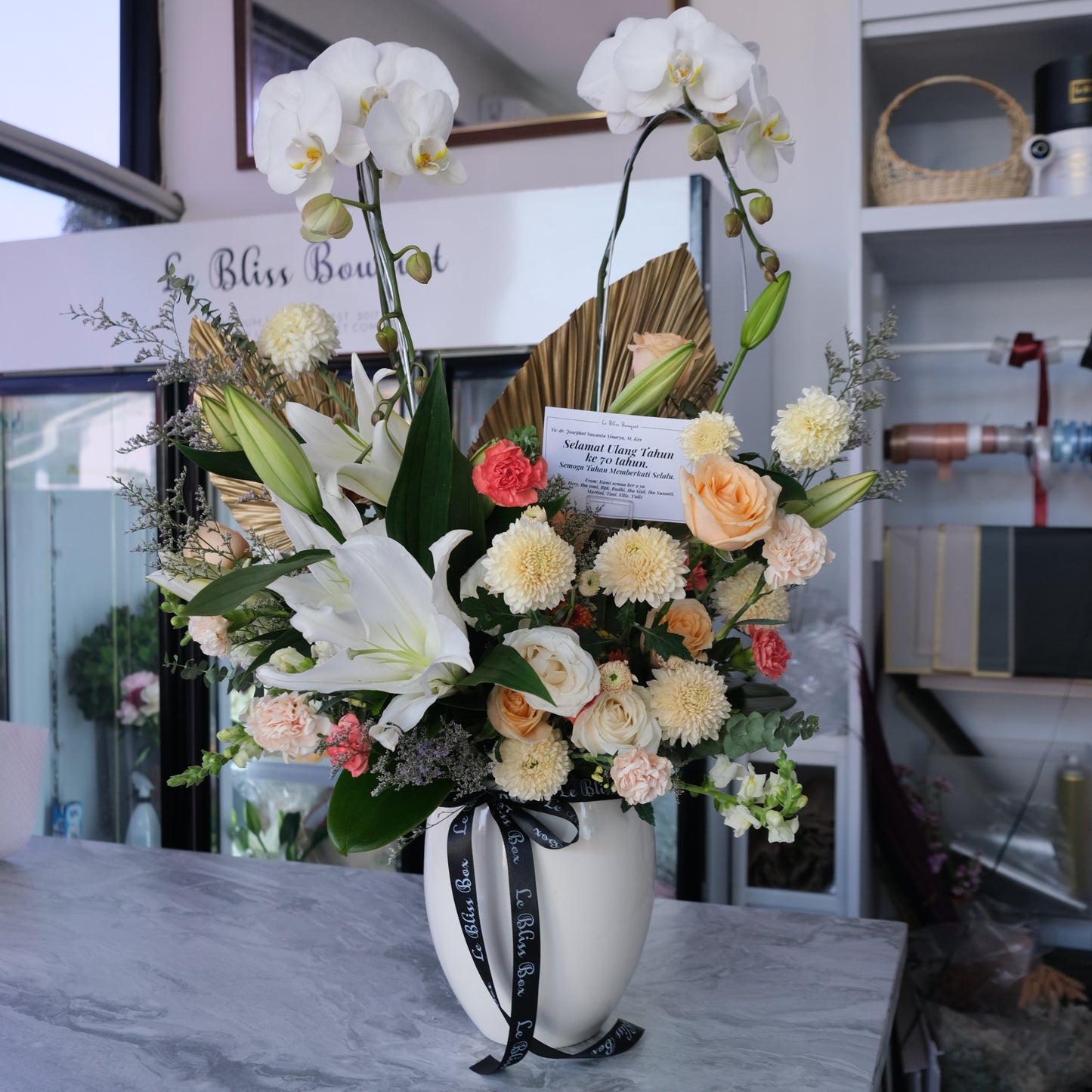Double orchid vase with white lilies and orange flowers from florist Surabaya, available for delivery to Cirebon, Jabodetabek, Sidoarjo, Gresik, and Majalengka.