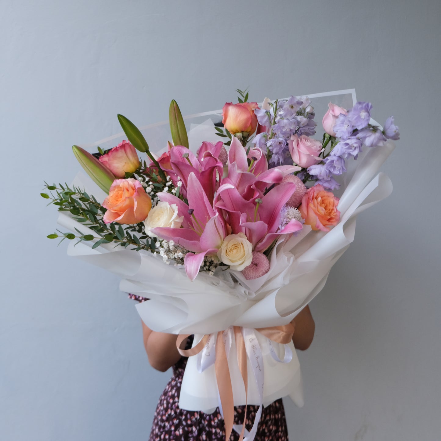 Elegant delphinium and pink lily bouquet in a soft floral arrangement for special occasions. Florist Cirebon & Bintaro.