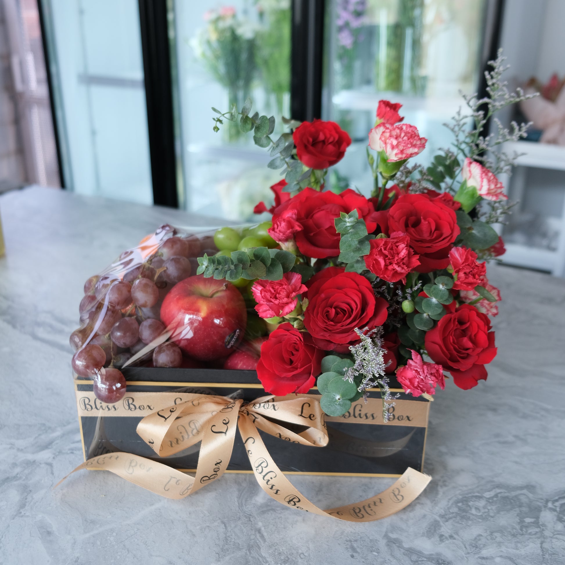 Festive Christmas Bloom Fruit Box filled with fresh premium fruits and beautiful festive blooms, perfect for Christmas celebrations. parcel buah jakarta