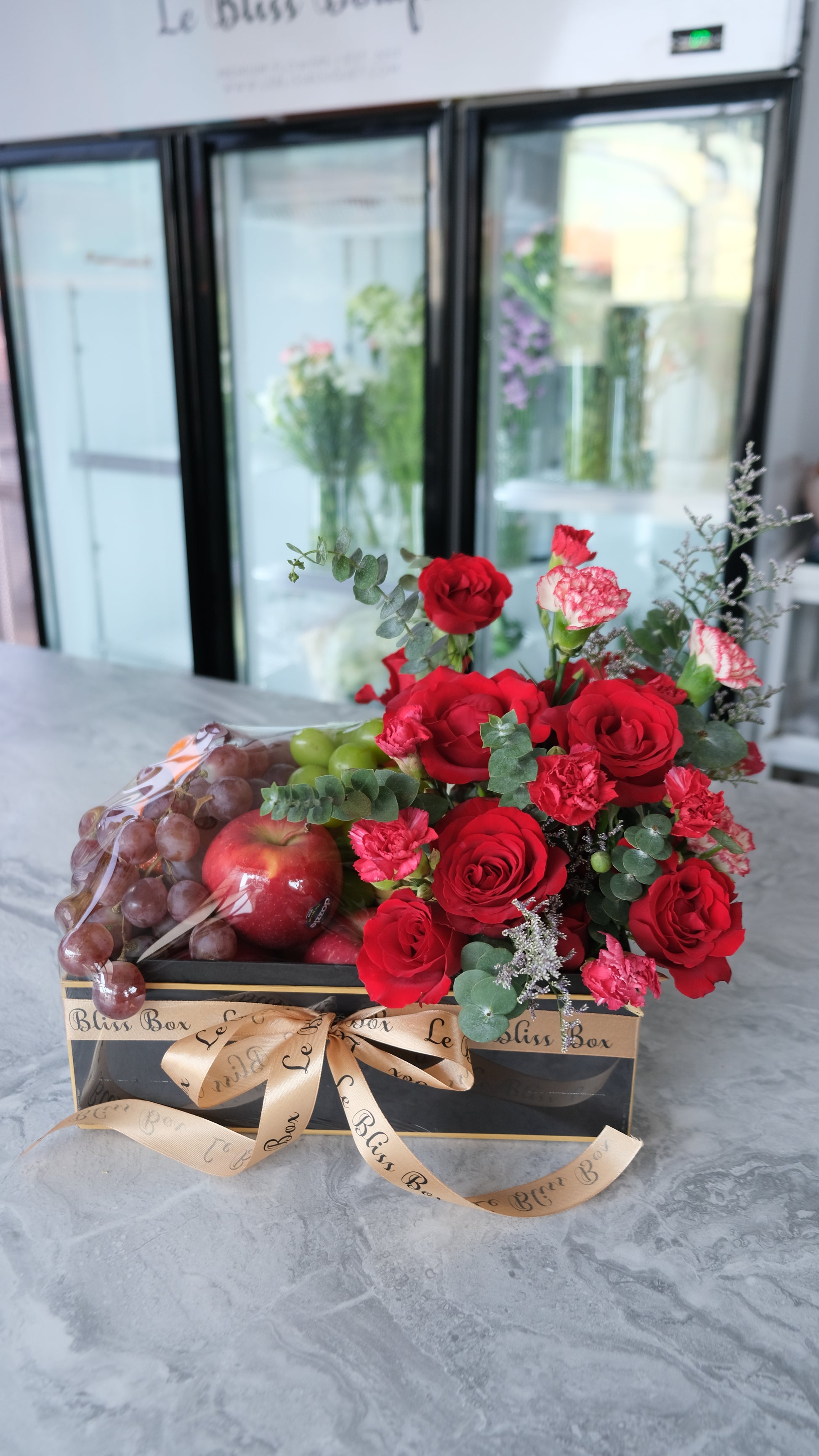 Festive Christmas Bloom Fruit Box filled with fresh premium fruits and beautiful festive blooms, perfect for Christmas celebrations. parcel buah surabaya, jakarta