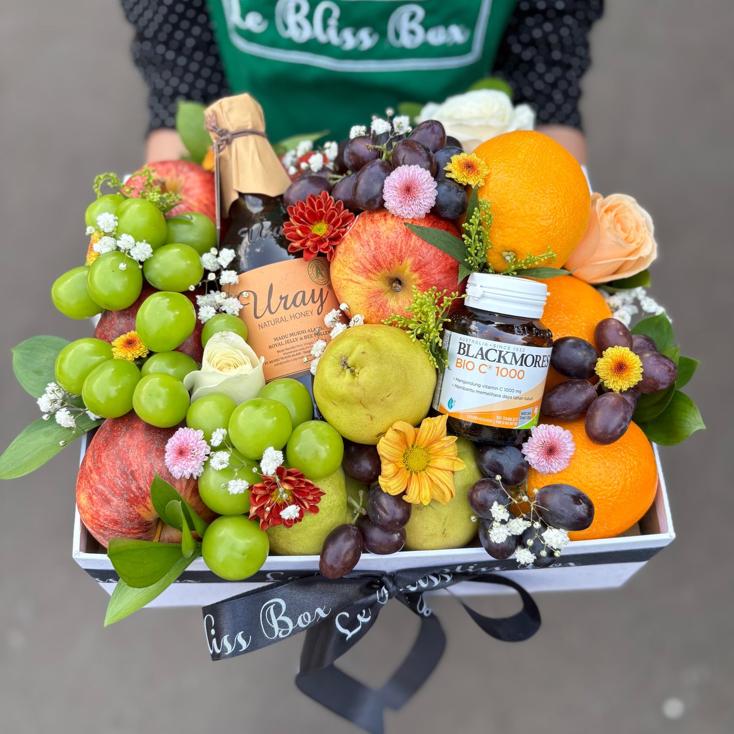 Fruit and flower arrangement with a bottle of Blackmores. fruit hamper surabaya, Jakarta, sidoarjo. parcel buah surabaya, jakarta, bintaro