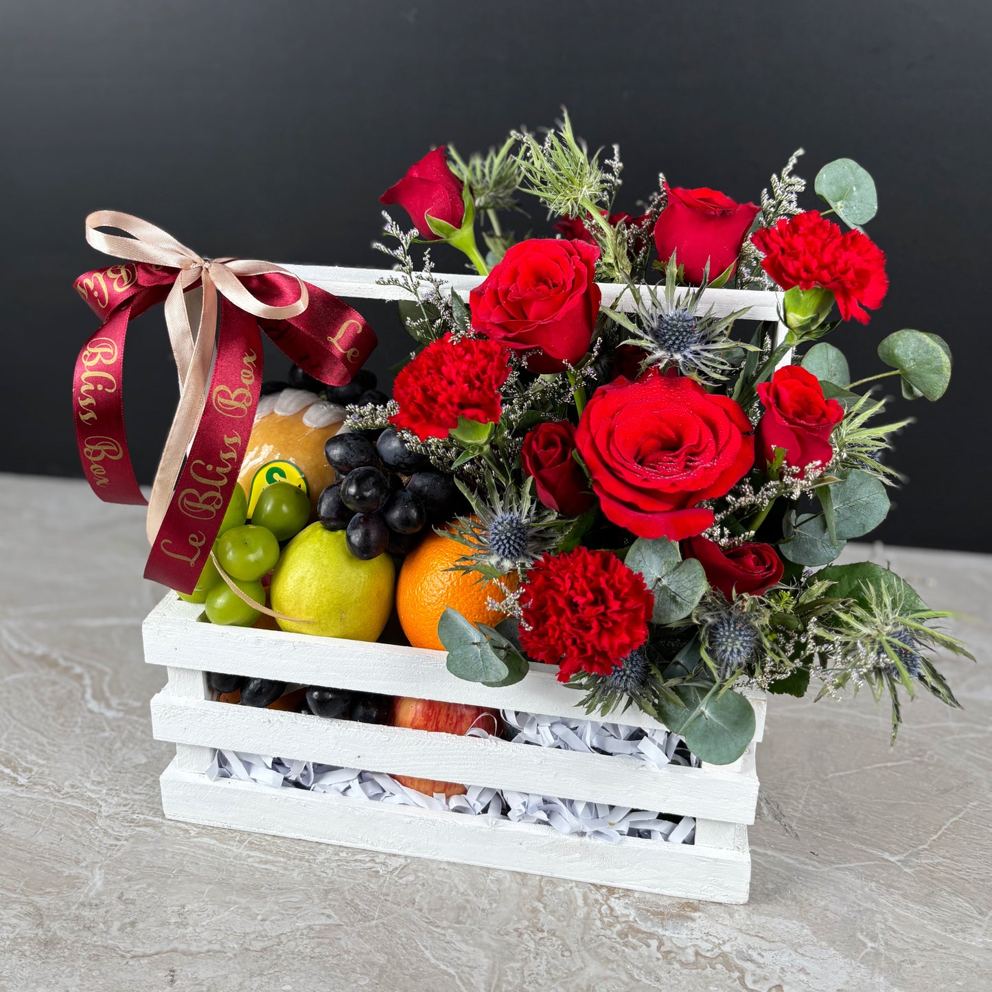 Fruit basket with red roses and decorative ribbon on a dark background. Fruit basket with red roses and a decorative ribbon on a gray surface. Fruit basket with red roses and a decorative ribbon on a dark background. parcel buah natal surabaya, parcel buah natal jakarta, parcel buah natal cirebon by le bliss box