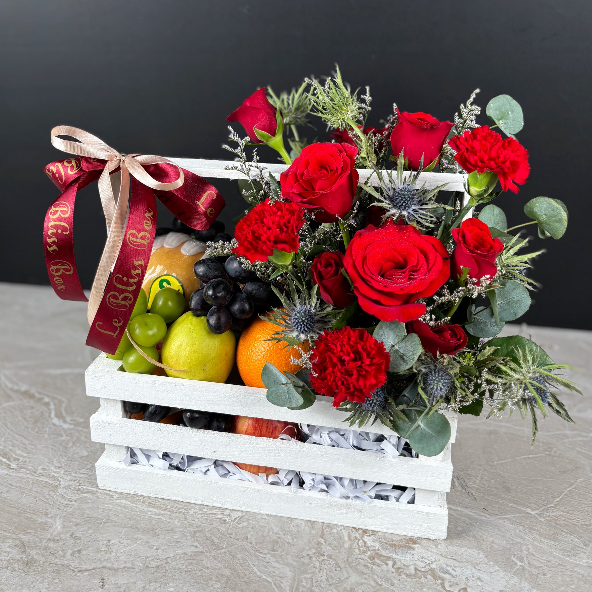 Fruit basket with red roses and decorative ribbon on a dark background. Fruit basket with red roses and a decorative ribbon on a gray surface. Fruit basket with red roses and a decorative ribbon on a dark background. parcel buah natal surabaya, parcel buah natal jakarta, parcel buah natal cirebon by le bliss box