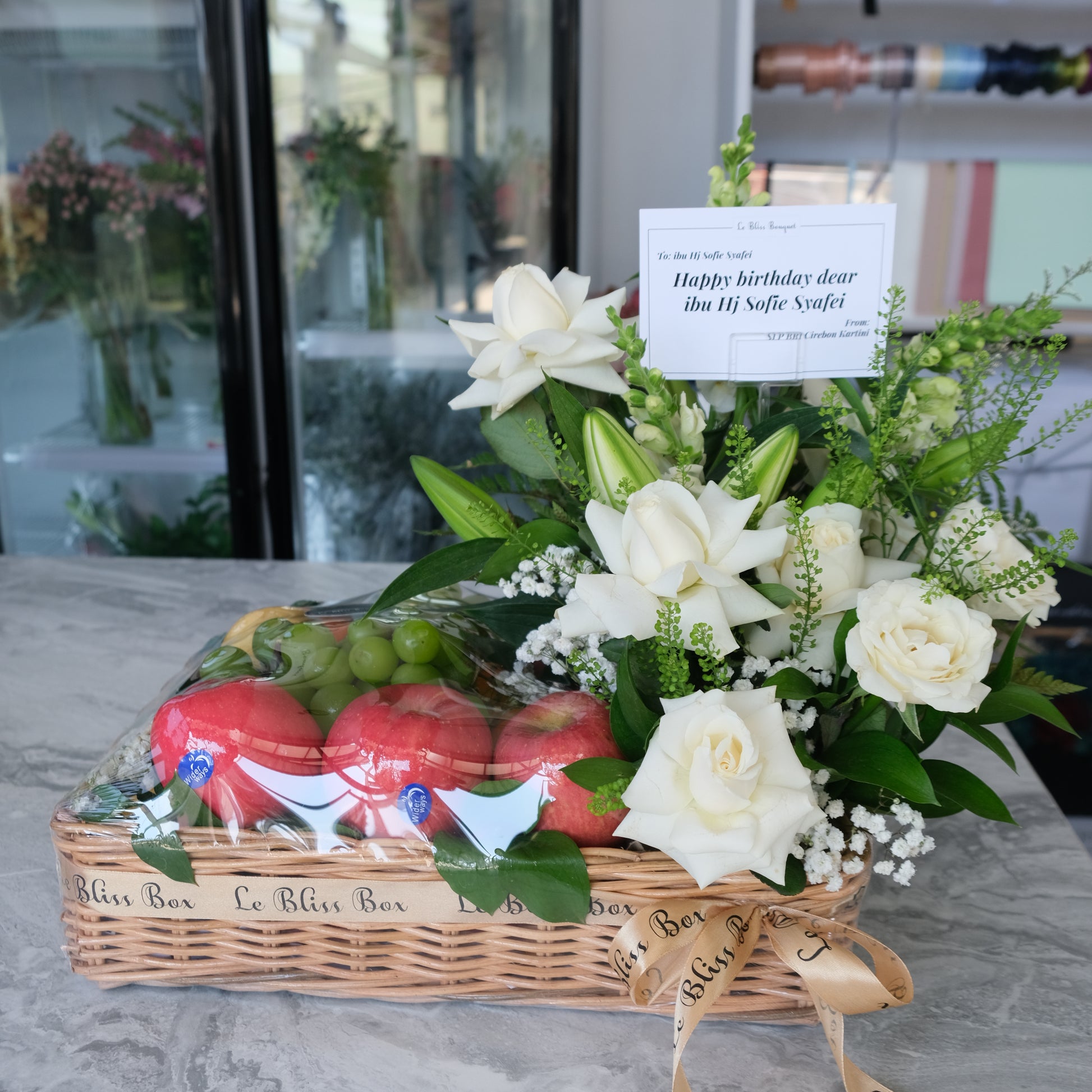Grand Rattan fruit Parcel with white roses and lilies by le bliss. parcel buah surabaya, hamper buah surabaya, fruit hamper surabaya by le bliss bouquet