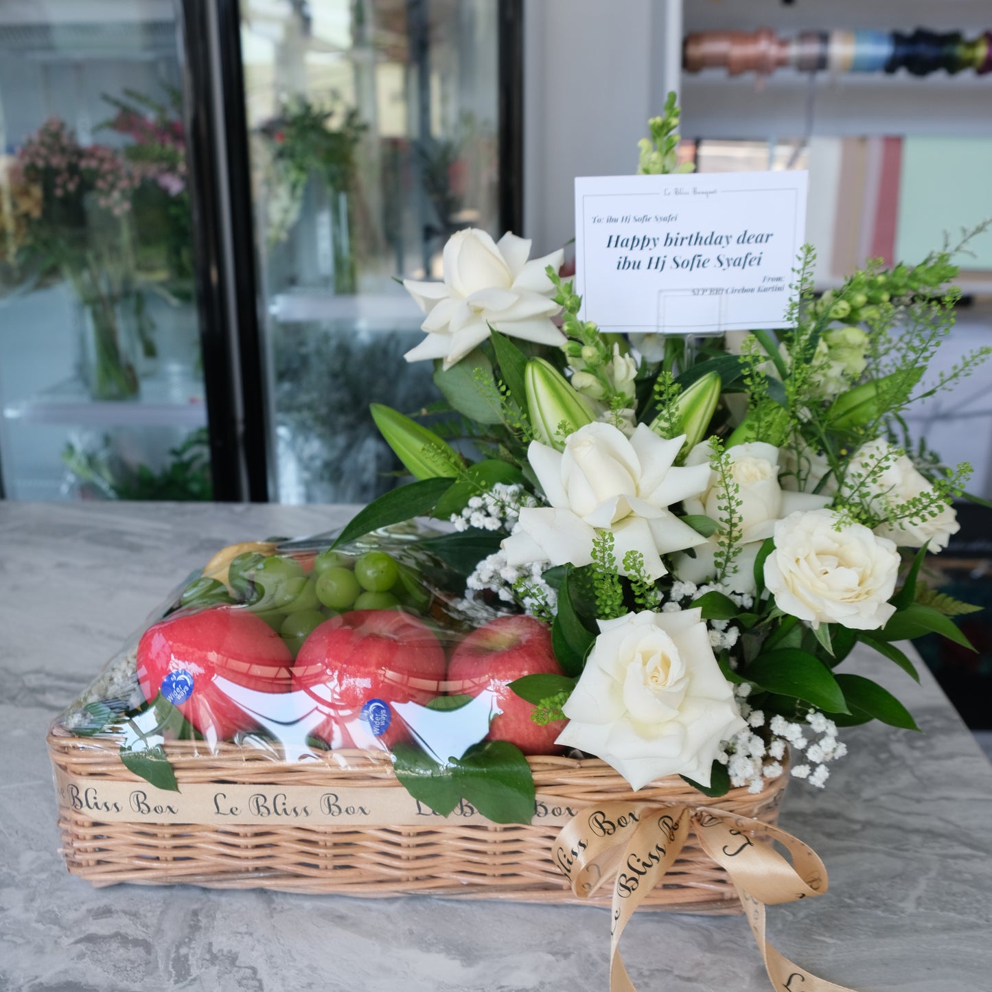 Grand Rattan fruit Parcel with white roses and lilies by le bliss box. parcel buah surabaya, hamper buah surabaya, fruit hamper surabaya by le bliss bouquet