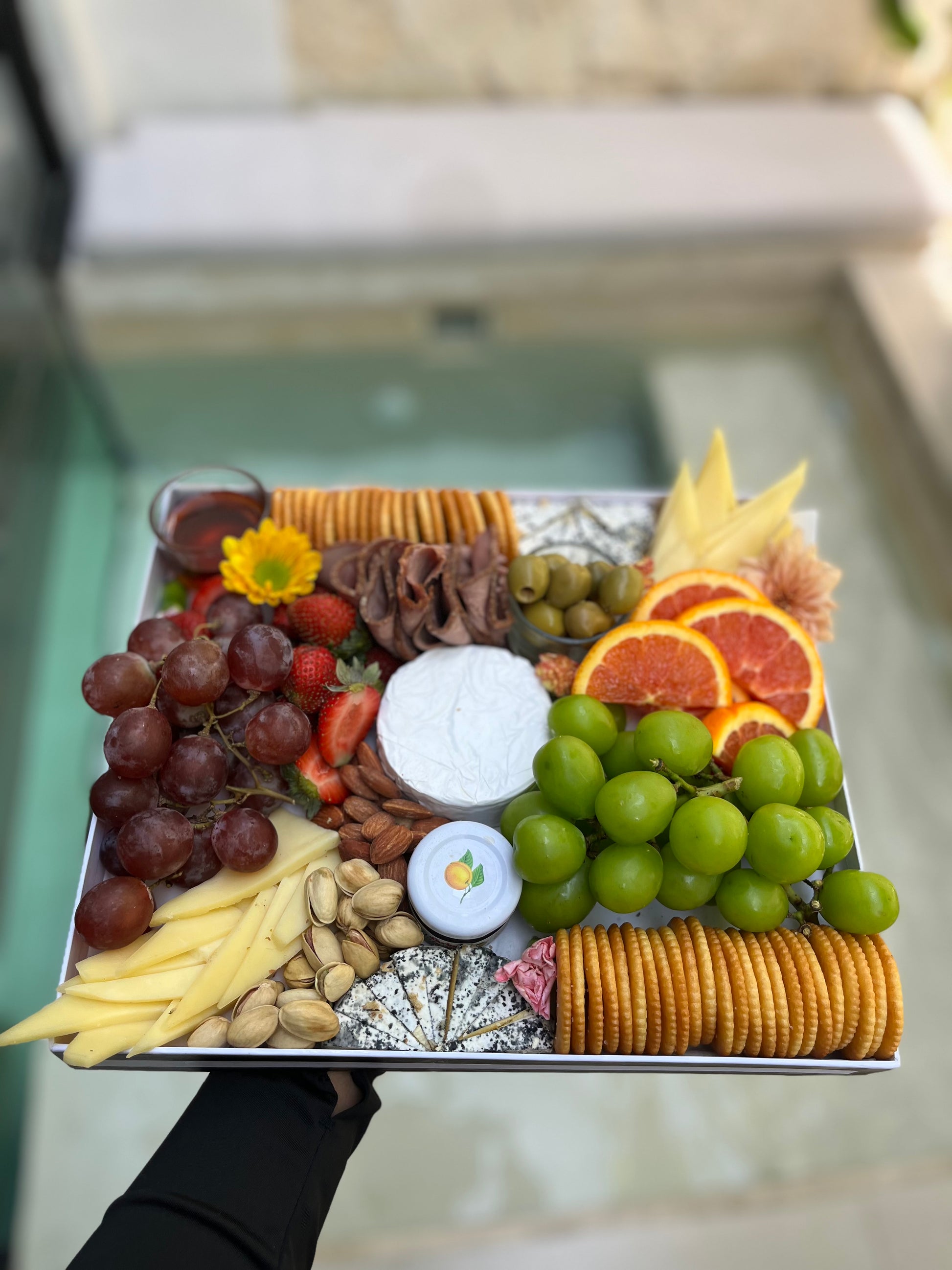 Jakarta charcuterie platter with cheese, cured meats, nuts, and grapes