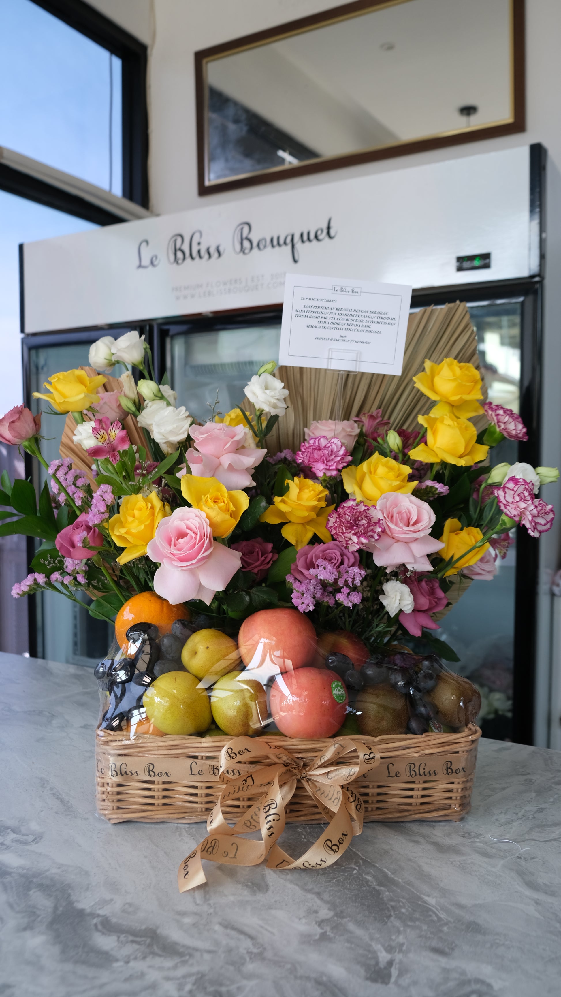 Parcel buah mewah dengan tema warna lilac dan kuning, berisi buah segar dan bunga premium dalam keranjang rotan — Lilac Yellow Grand Fruit Hamper Le Bliss Surabaya.