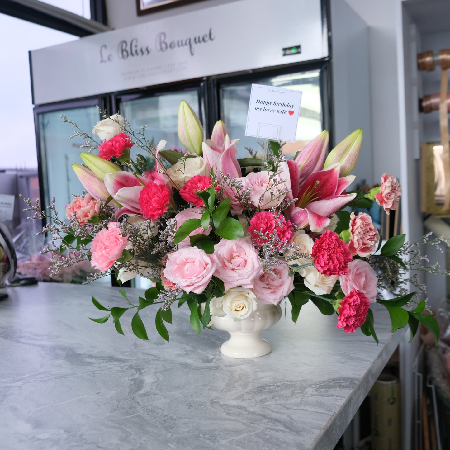 Premium vase arrangement with lilies, rose, and carnation in shades of pink by le bliss bouquet, vas arrangement delivery to surabaya. bunga meja pengiriman ke surabaya