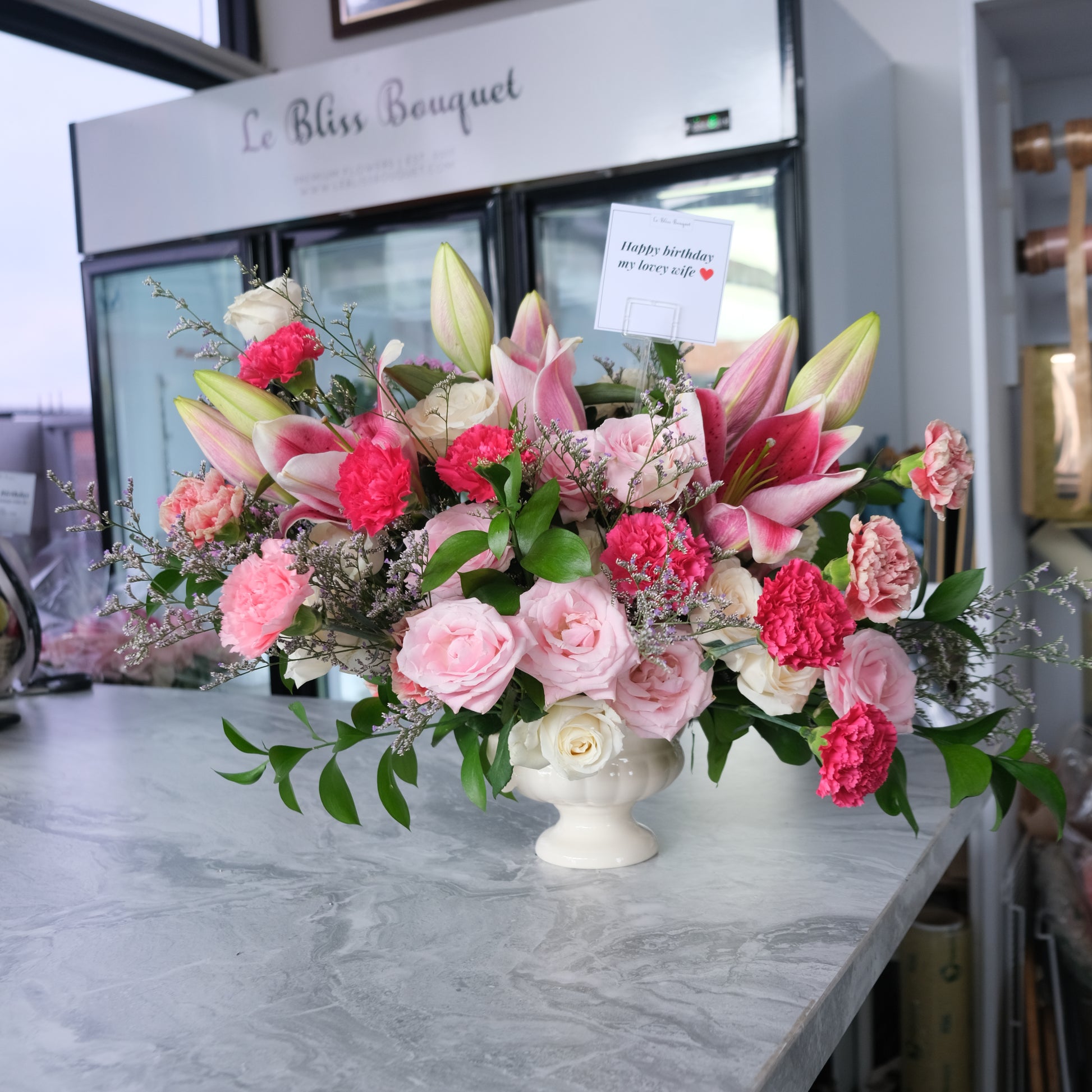 Premium vase arrangement with lilies, rose, and carnation in shades of pink by le bliss bouquet, vas arrangement delivery to surabaya. bunga meja pengiriman ke surabaya