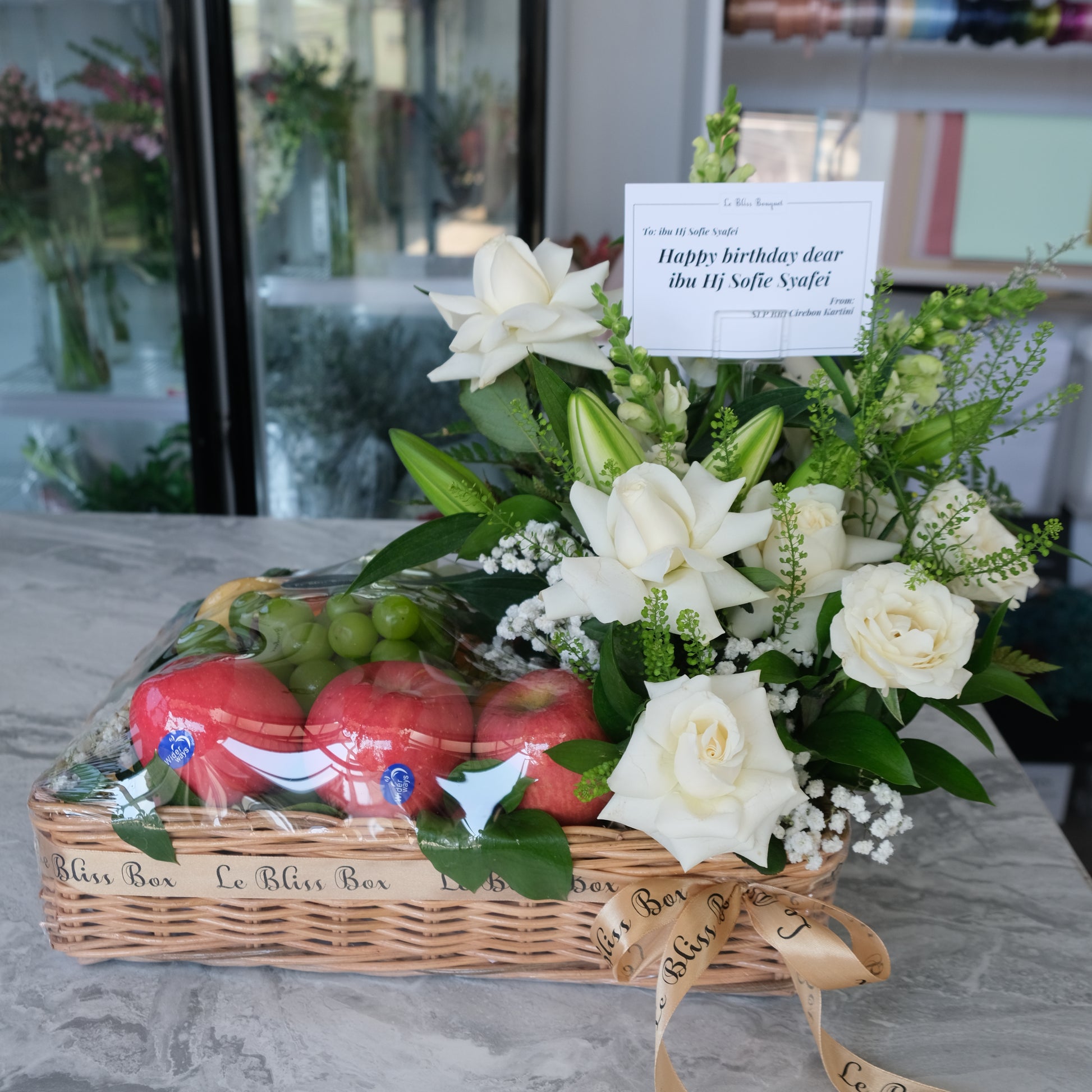 Rattan fruit Parcel with white roses and lilies by le bliss box. parcel buah surabaya, hamper buah surabaya, fruit hamper surabaya by le bliss bouquet