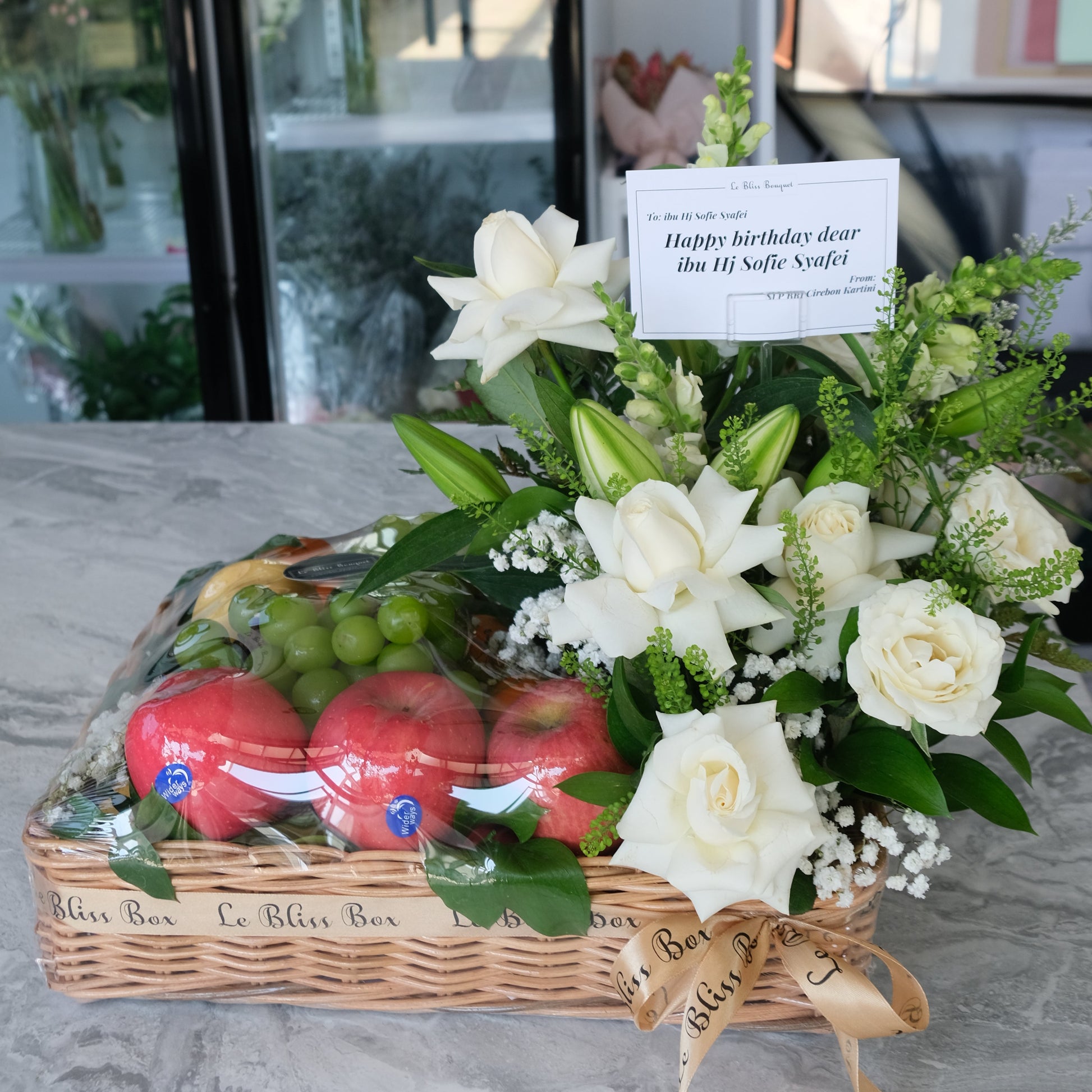 Rattan fruit Parcel with white roses and lilies by le bliss box | parcel buah surabaya, hamper buah surabaya, fruit hamper surabaya
