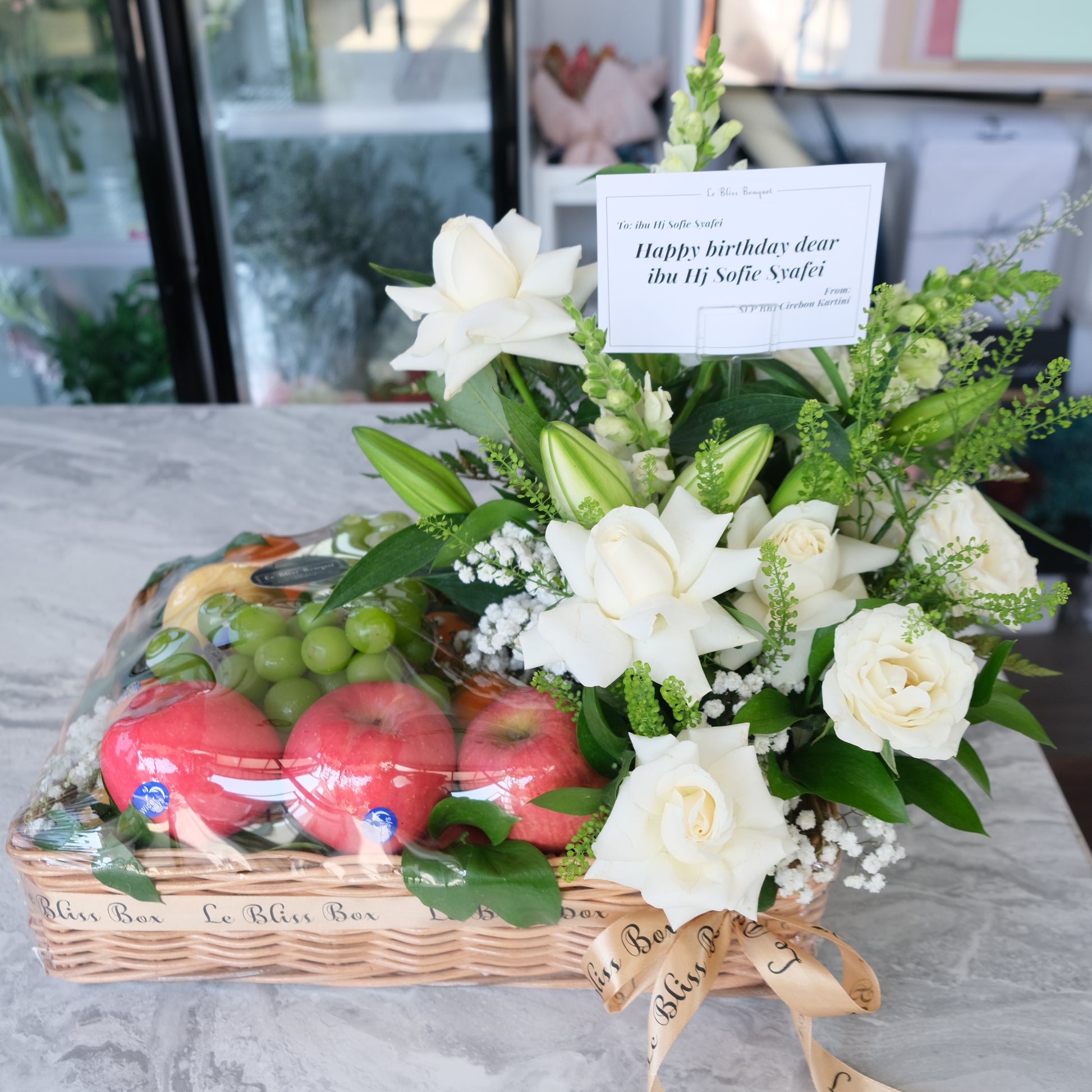 Rattan fruit Parcel with white roses and lilies by le bliss box | parcel buah surabaya, hamper buah surabaya, fruit hamper surabaya by le bliss bouquet
