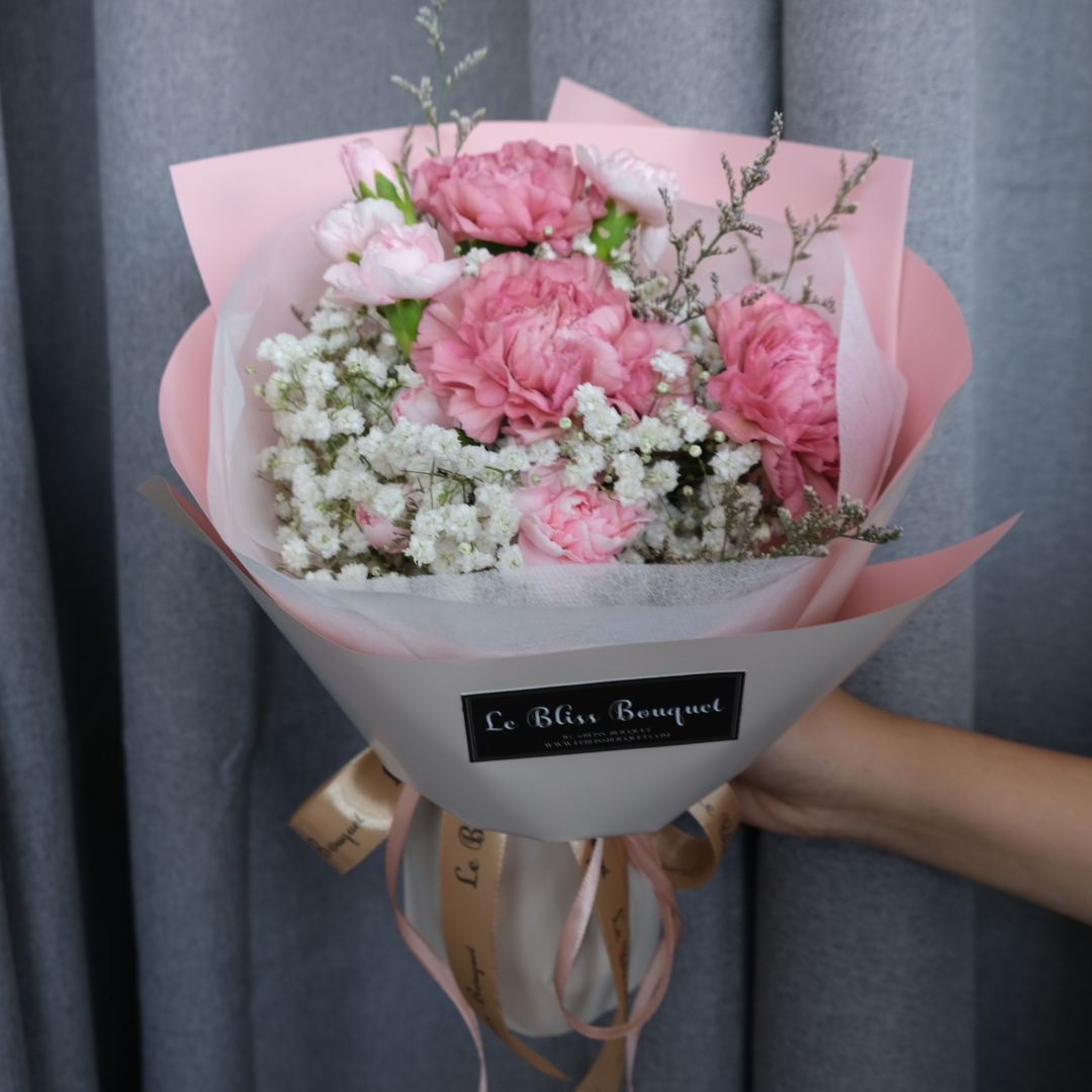 Round bouquet of soft pink carnations with pastel wrapping – sweet flower gift by Le Bliss for delivery Surabaya
