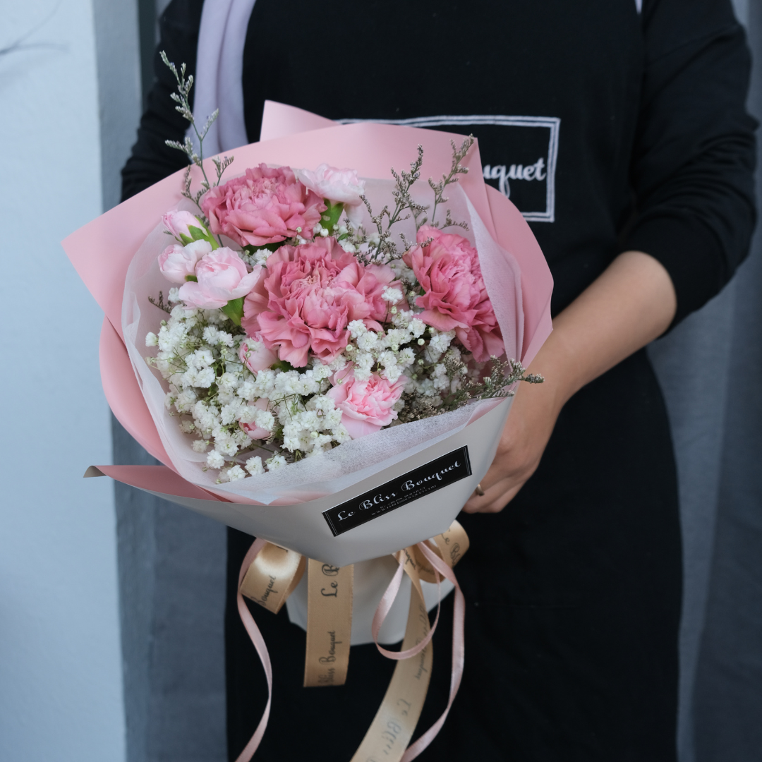 Round bouquet of soft pink carnations with pastel wrapping – sweet flower gift by Le Bliss for delivery in Jakarta, Surabaya, Tangerang & Cirebon