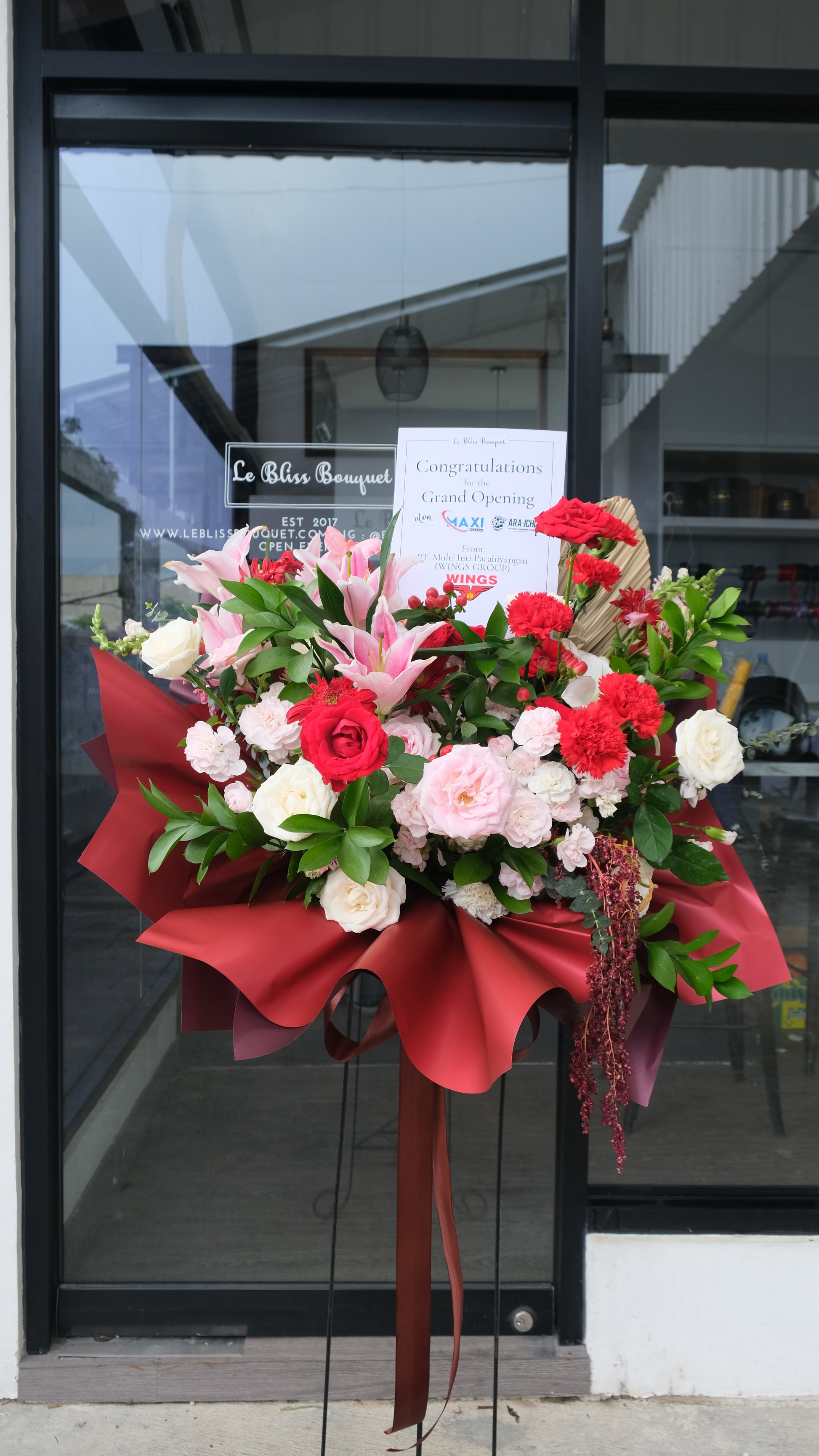 Standing flower warna merah dengan mawar, gerbera, dan bunga eksotis lainnya, rangkaian bunga duka cita dan grand opening elegan dari Le Bliss Bouquet – pengiriman ke Jakarta