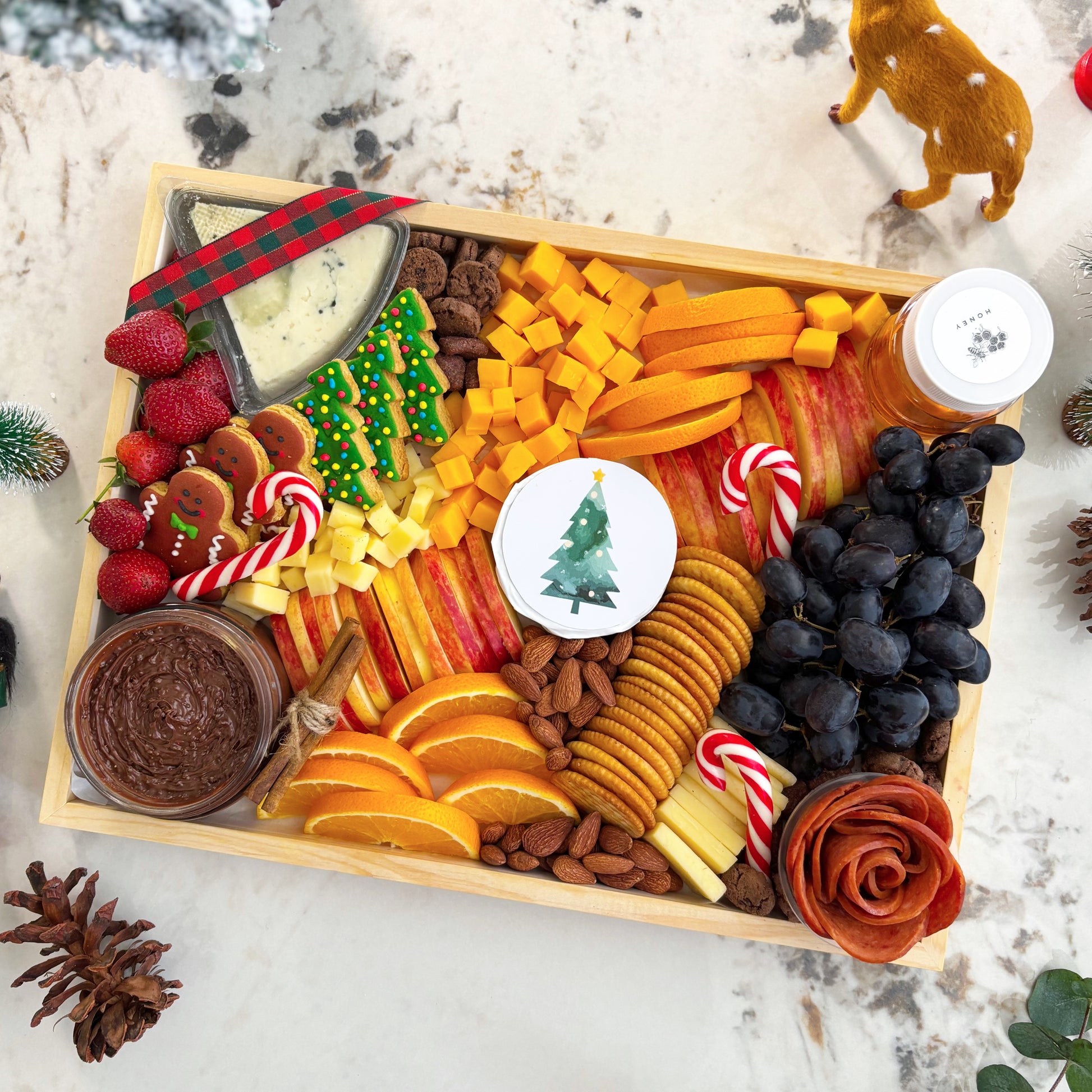 charcuterie board with fruits, cheese, and other treats on a marble surface.  Christmas Xtra Cheese Platter | Best Cheese Platter in Jakarta & Surabaya – Le Bliss Platter