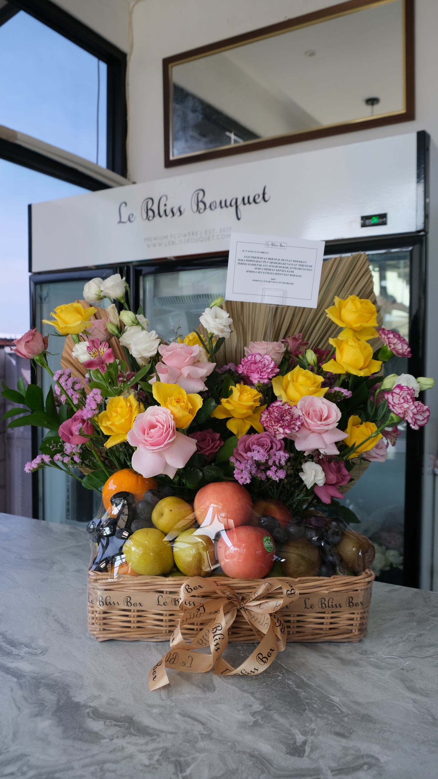 Parcel buah mewah dengan tema warna lilac dan kuning, berisi buah segar dan bunga premium dalam keranjang rotan — Lilac Yellow Grand Fruit Hamper Le Bliss Surabaya.