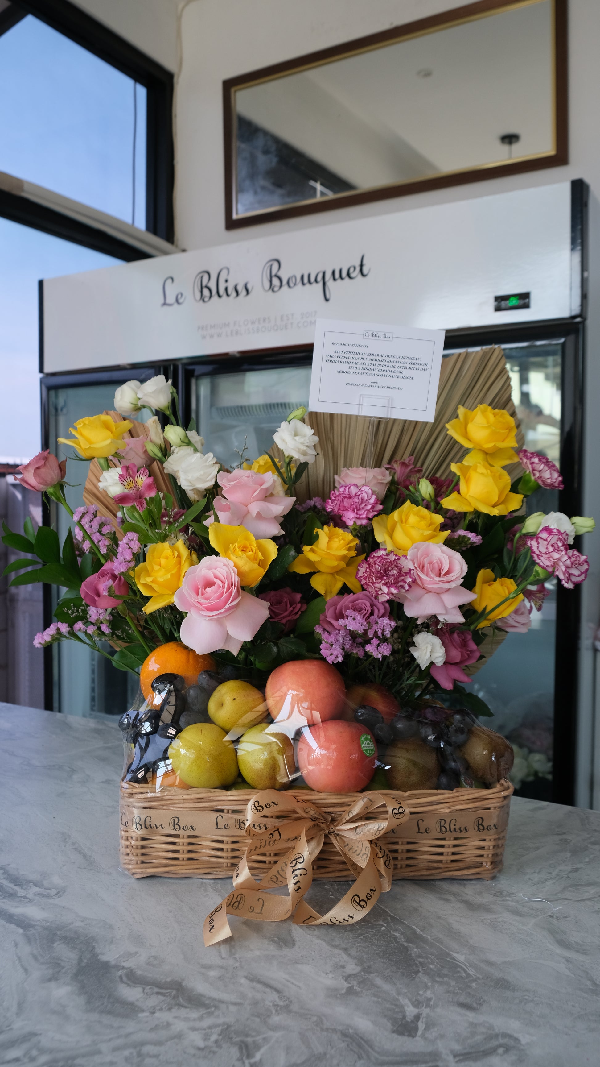 Parcel buah mewah dengan tema warna lilac dan kuning, berisi buah segar dan bunga premium dalam keranjang rotan — Lilac Yellow Grand Fruit Hamper Le Bliss Surabaya.