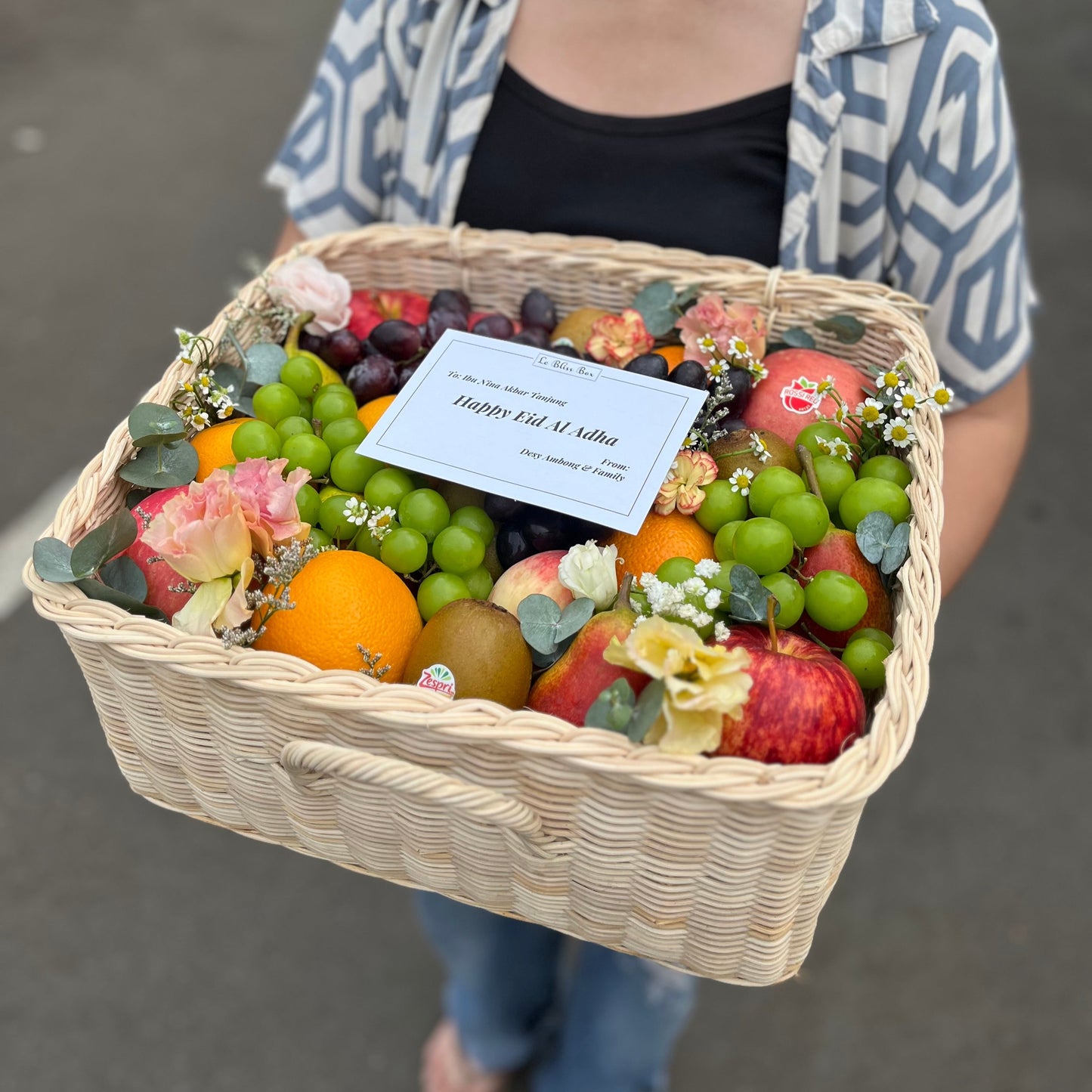 Kotak buah anyaman rotan dengan hiasan bunga segar dari Le Bliss Bouquet, pilihan hadiah elegan dan sehat untuk berbagai acara. Parcel Buah Jakarta - Fruit Hamper Bintaro dan Jakarta | Toko Parcel Buah Mewah by Le Bliss Box