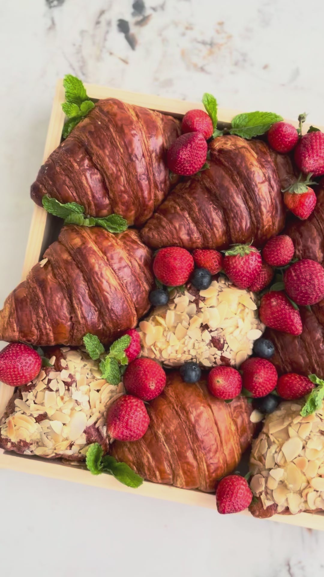 Box of croissants and pastries with berries on a marble surface. best platter in jakarta, best platter in surabaya