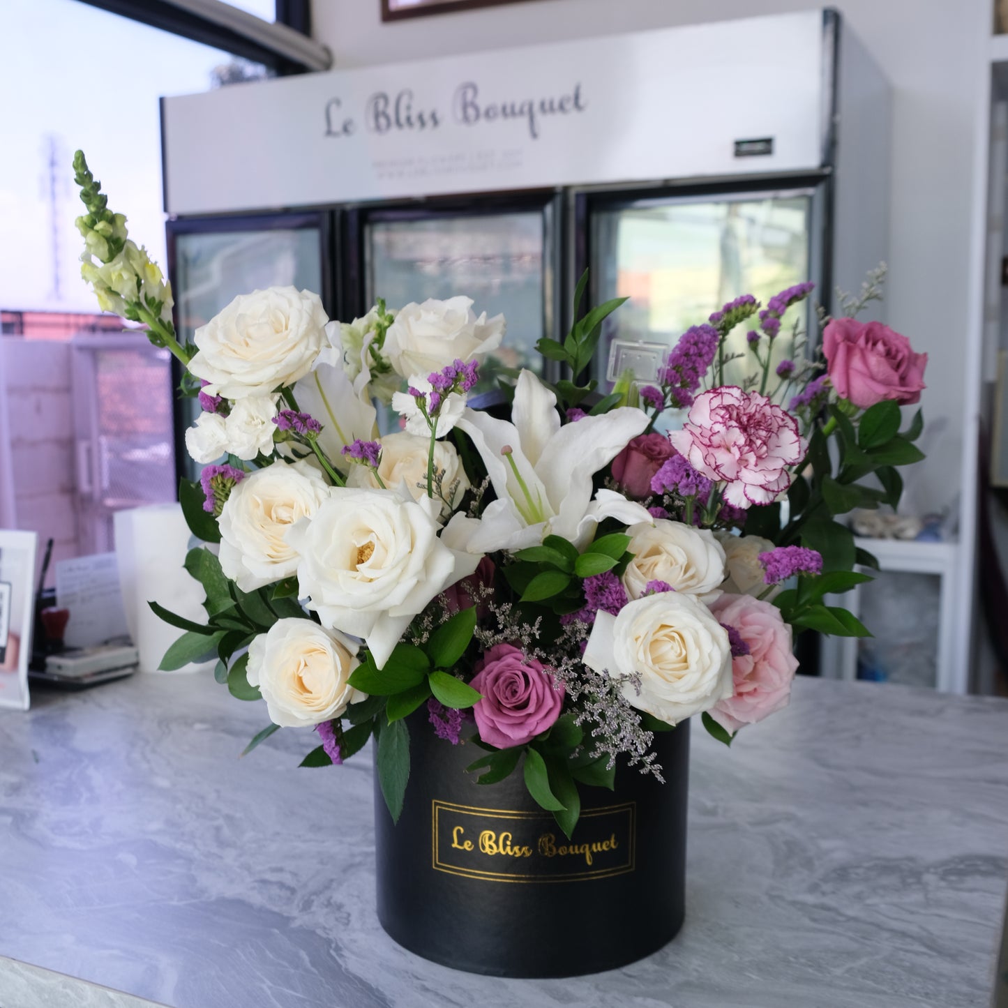 rangkaian bunga lily putih, mawar ungu, carnation di dalam box hitam premium by Le Bliss Bouquet. fresh flower delivery, florist surabaya, Toko Bunga surabaya, bunga meja surabaya.
