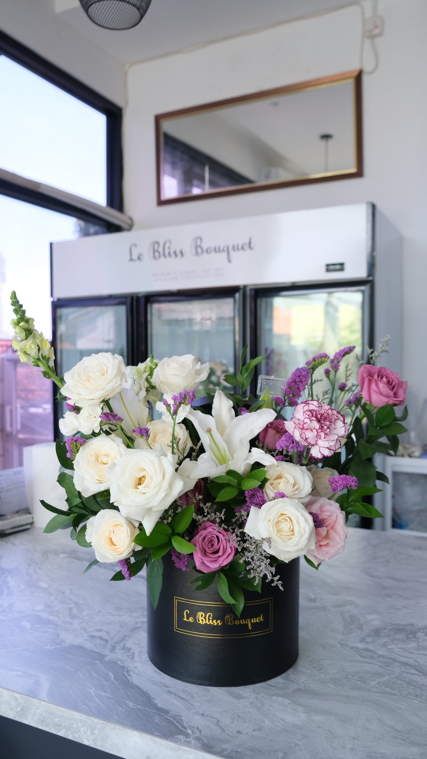 rangkaian bunga lily putih, mawar ungu, carnation di dalam box hitam premium by Le Bliss Bouquet. fresh flower delivery, florist surabaya, Toko Bunga surabaya, bunga meja surabaya. bloombox surabaya